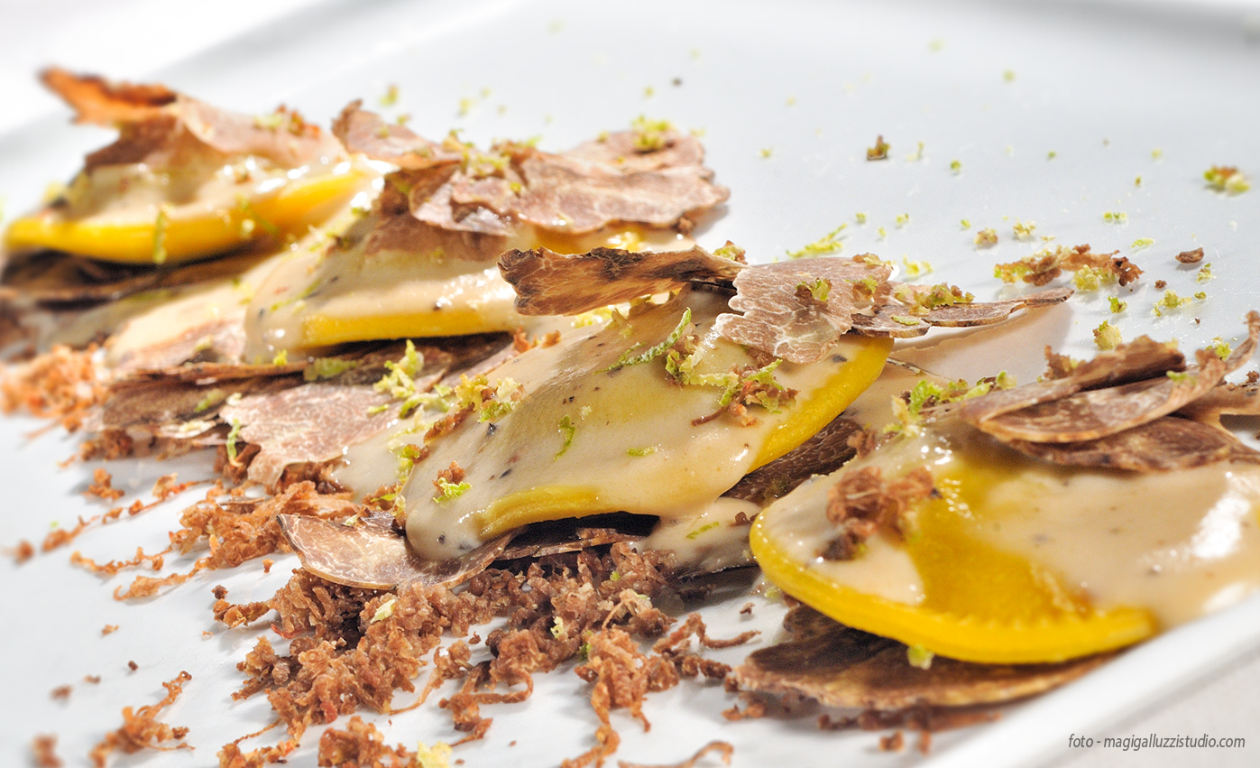 Truffle ravioli with fried garnish on a white plate