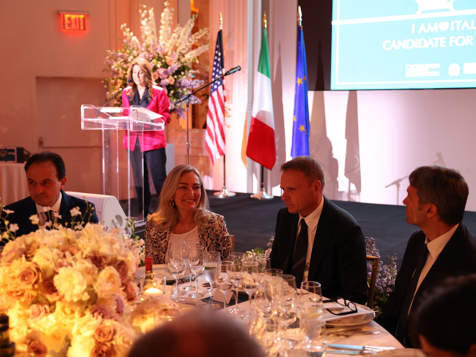 Formal corporate dinner with Italian, US and EU flags