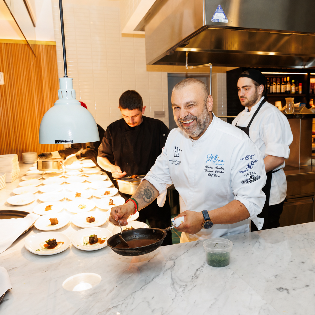 Chef Fabrizio Facchini finishing plates at a live custom chef station