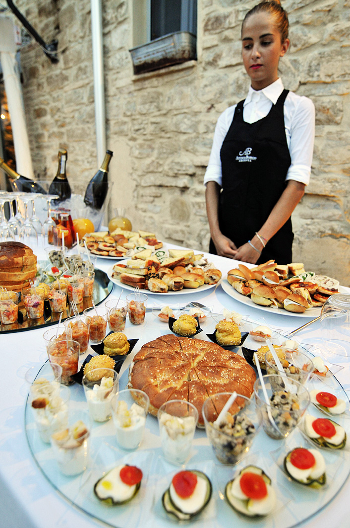 Server presenting an Italian antipasti and finger-food buffet at a private event