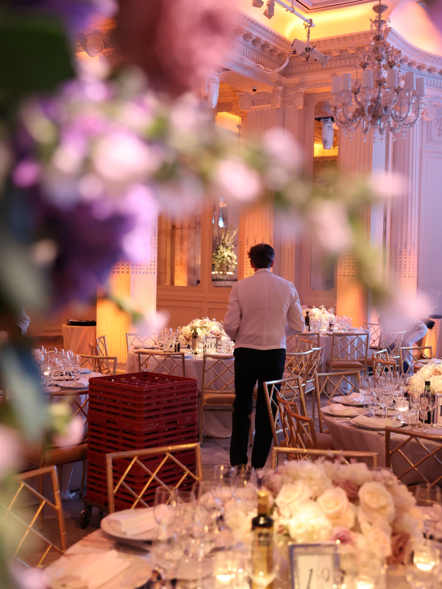 Ballroom wedding reception with candlelit tables, gold chairs, and white floral centerpieces
