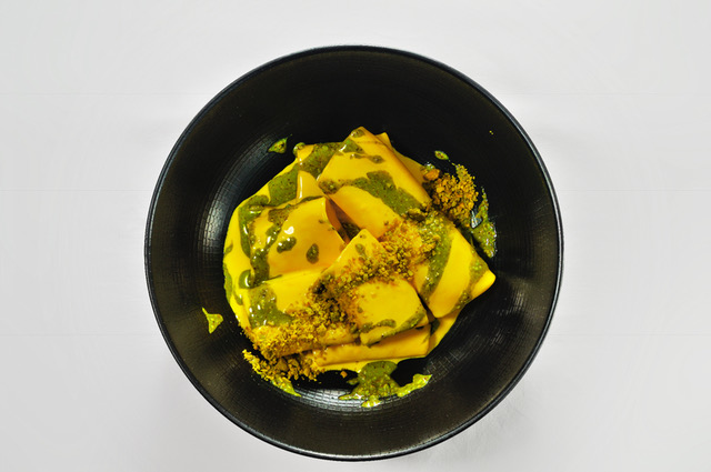 Yellow ravioli with green sauce and toasted crumbs