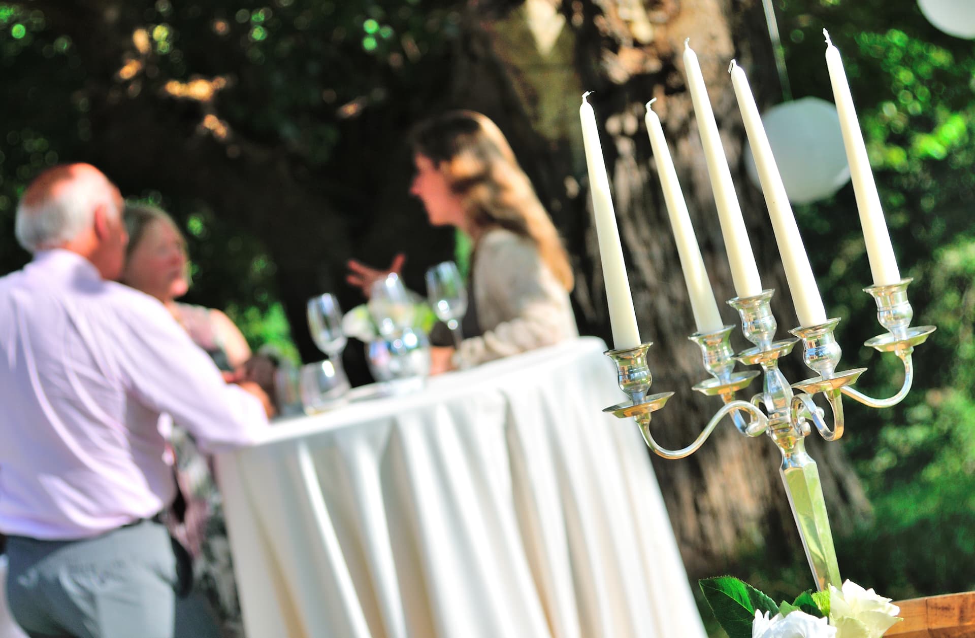 Silver candelabra and cocktail table during a garden wedding aperitivo