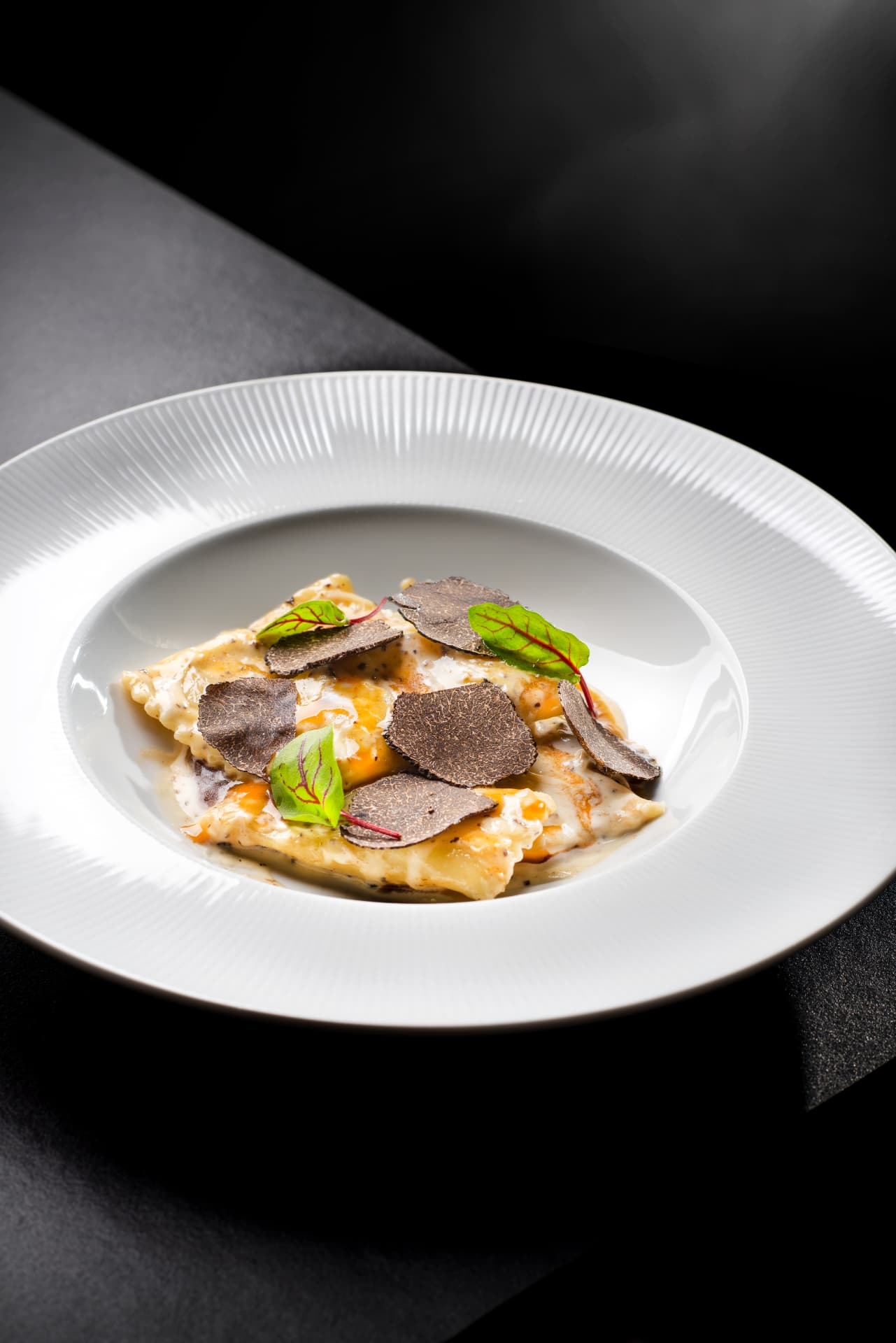 Handmade ravioli finished with black truffle and fresh herbs