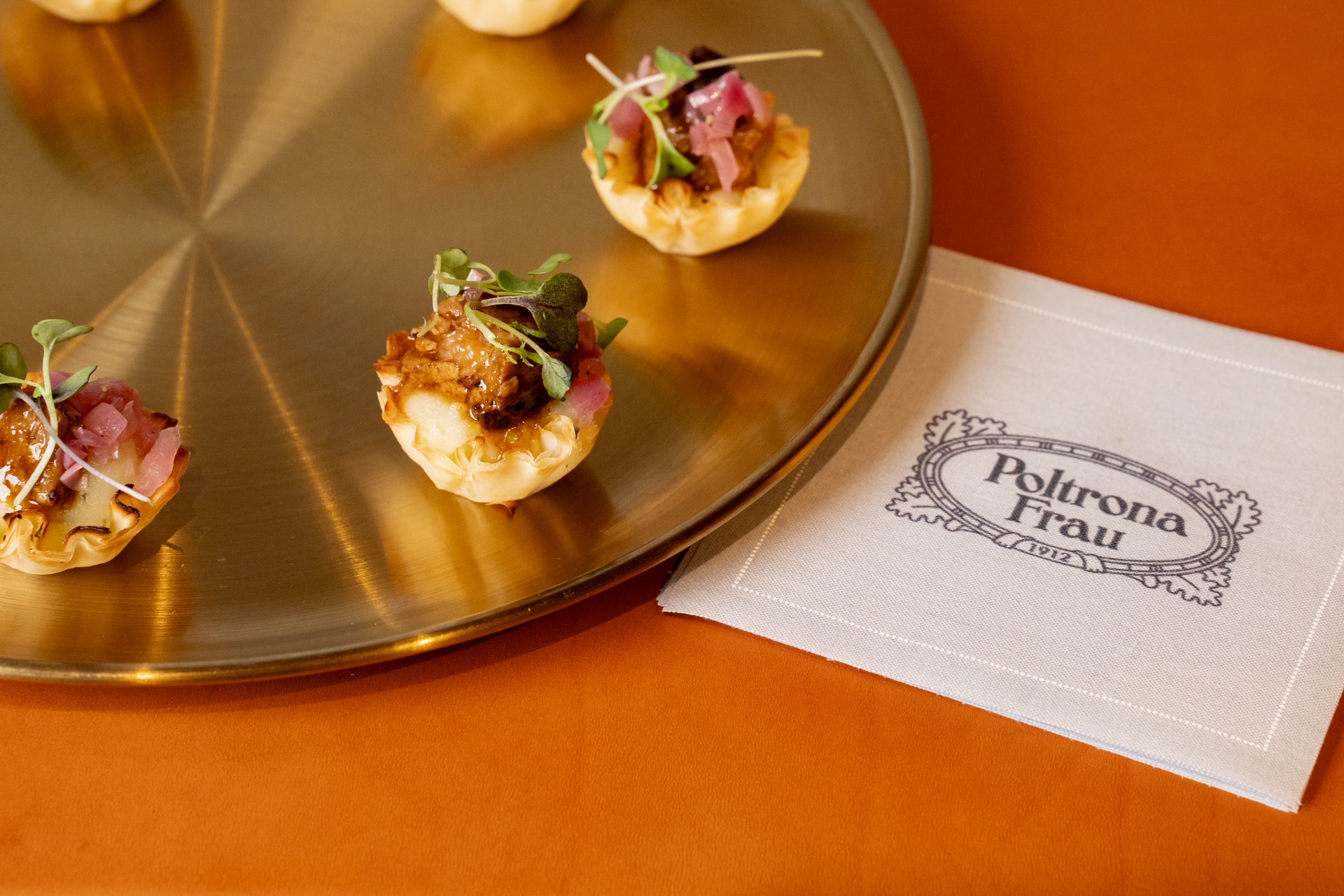 Passed hors d'oeuvres presented on a gold tray at a cocktail reception