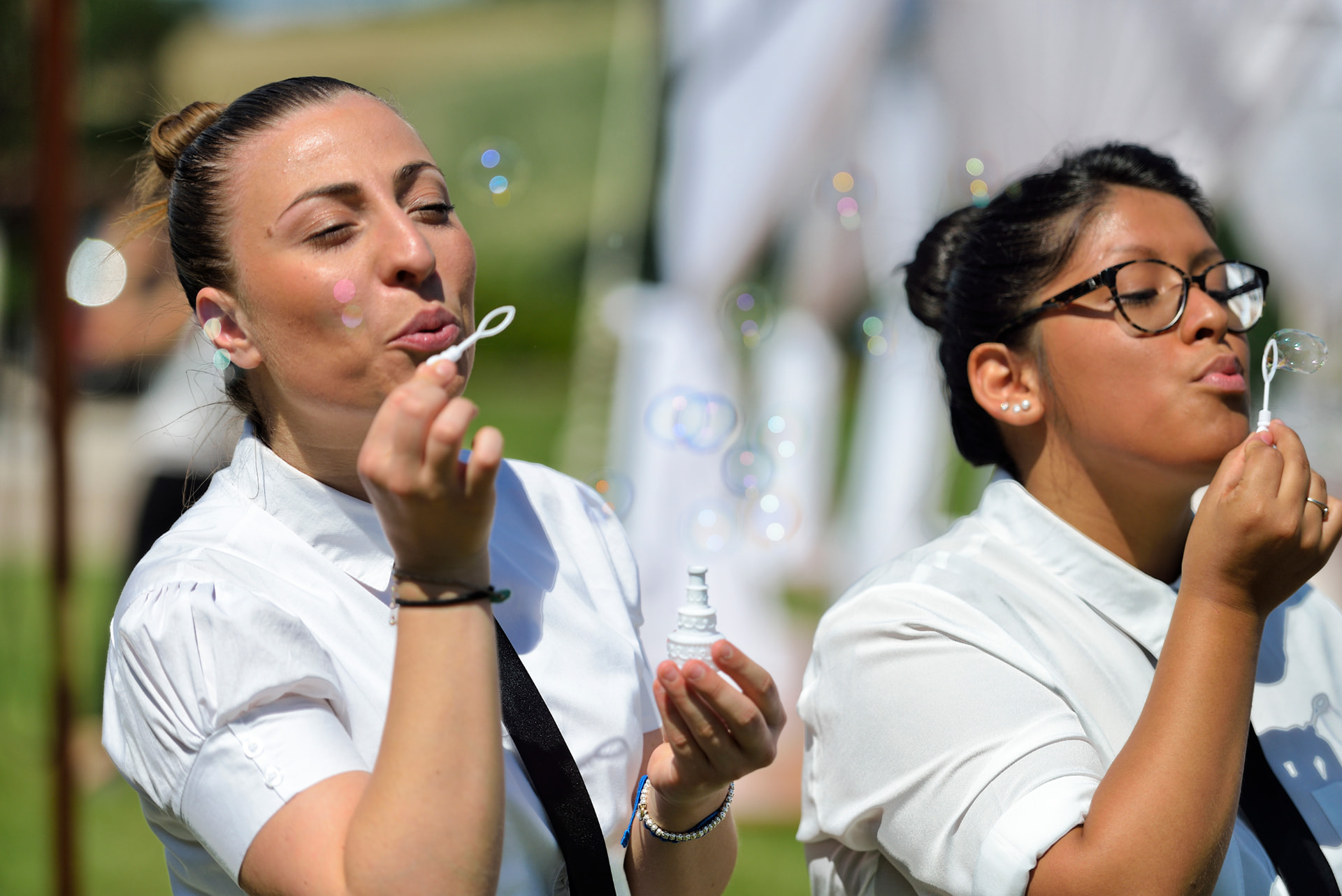 Service team blowing bubbles during an outdoor wedding celebration